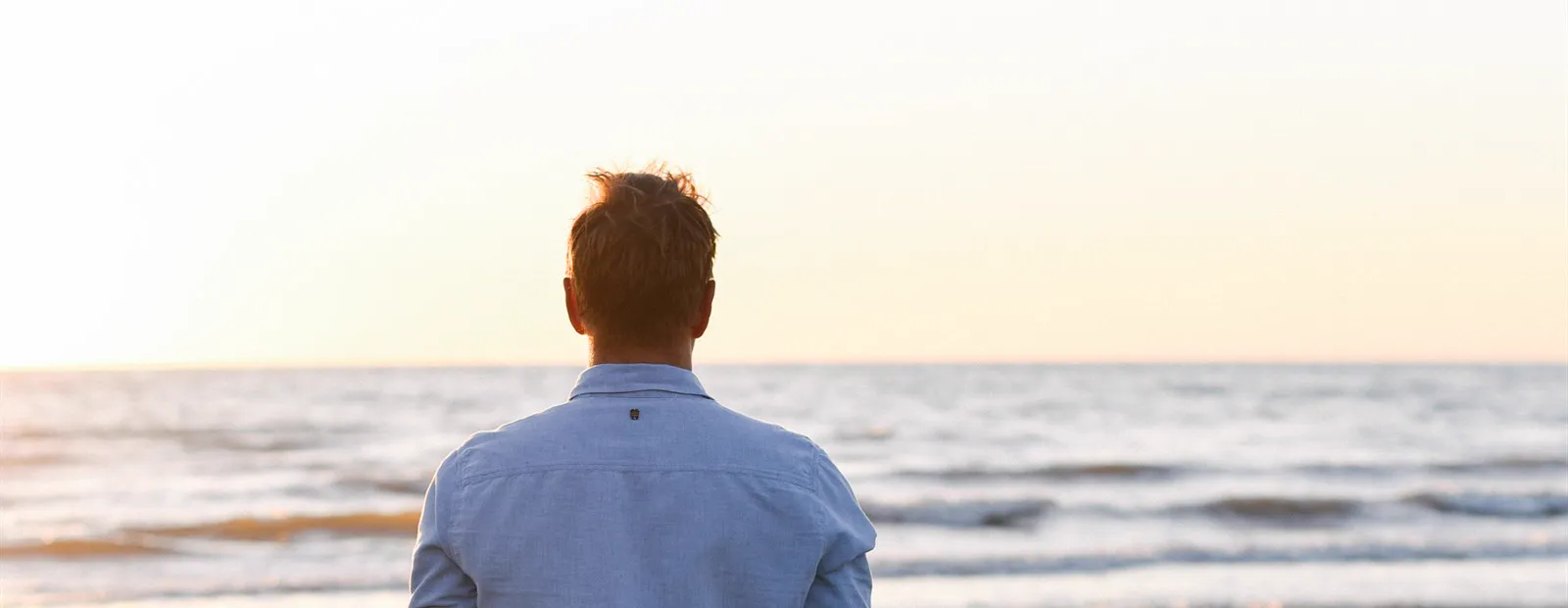 Bas kijkt vanaf het strand uit over de zee