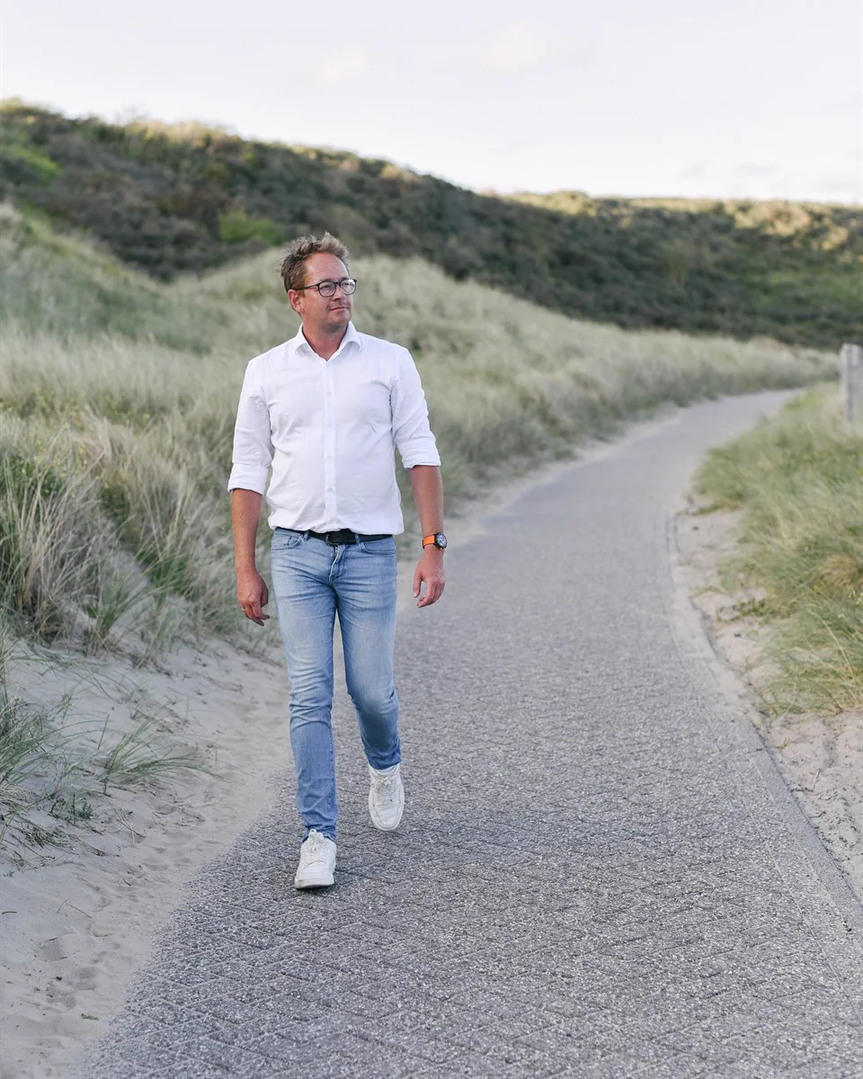 Bas wandelt door de duinen tijdens een coachingswandeling